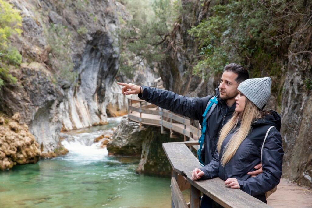 Couple standing on a wooden bridge surrounded by lush greenery in Kumrat Valley, Pakistan